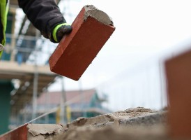Bricklayer laying a brick