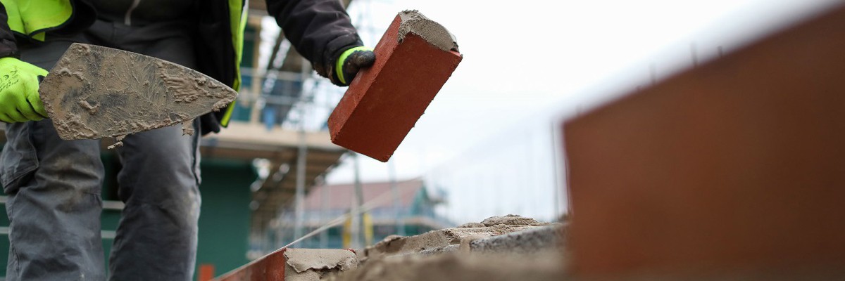 Bricklayer laying a brick