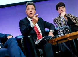 Three people speaking at a conference